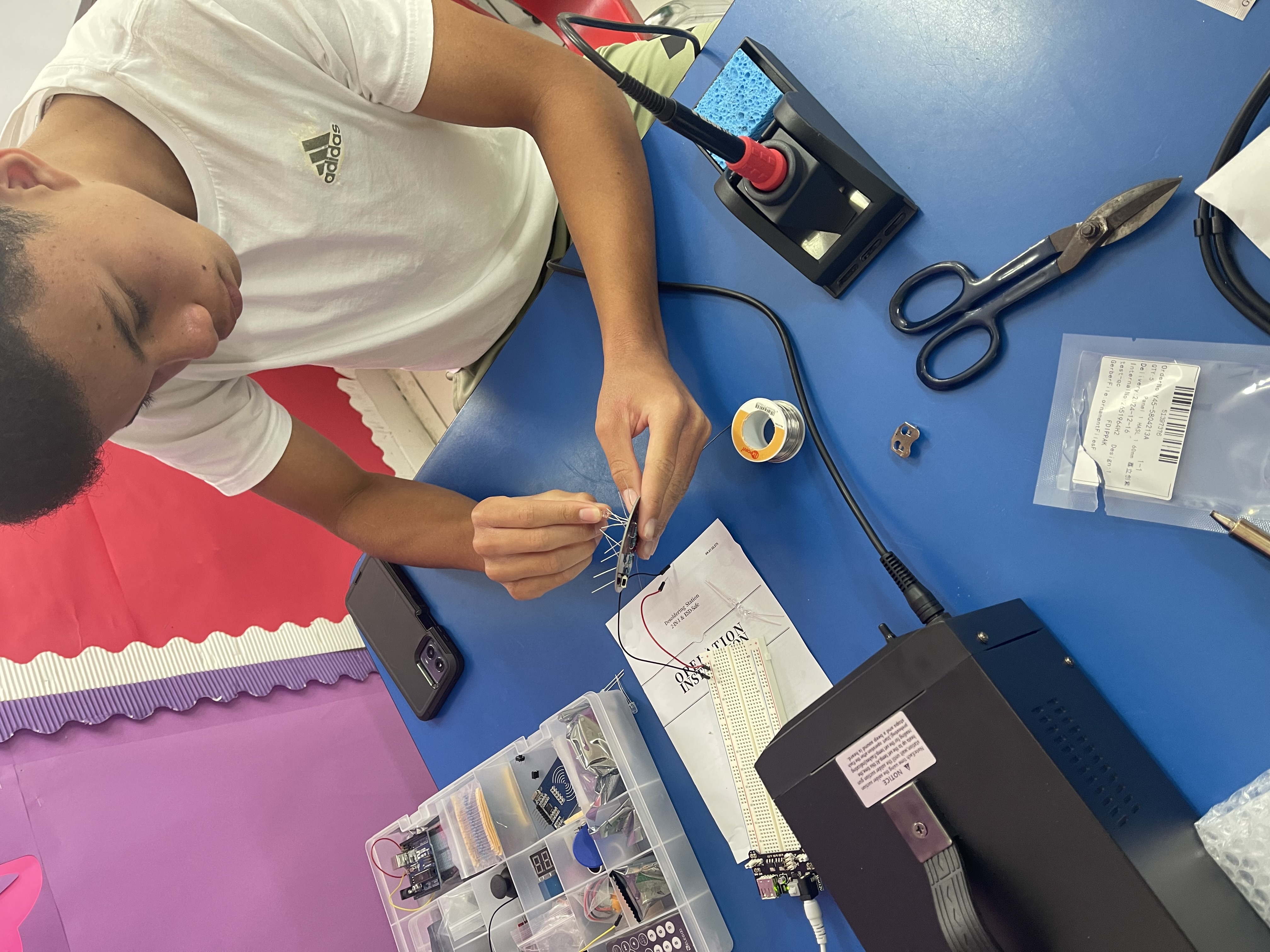 Student soldering at a workshop bench